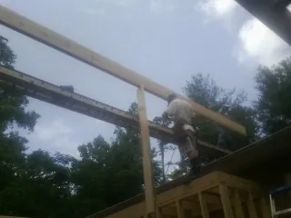 Carpenter setting a ridge beam over a new addition frame — Ice Dam Removal by Roofing Brothers in Seaside Park