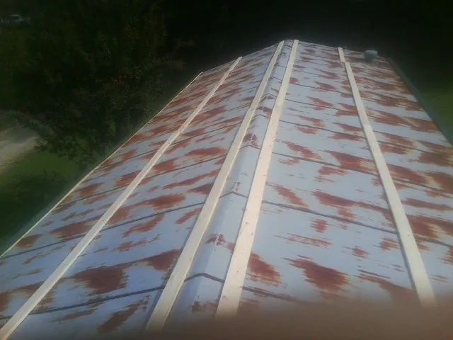 Rusted metal roof panels with new wood purlins before replacement — Storm Damage Roof Repair in Seaside Park by Roofing Brothers