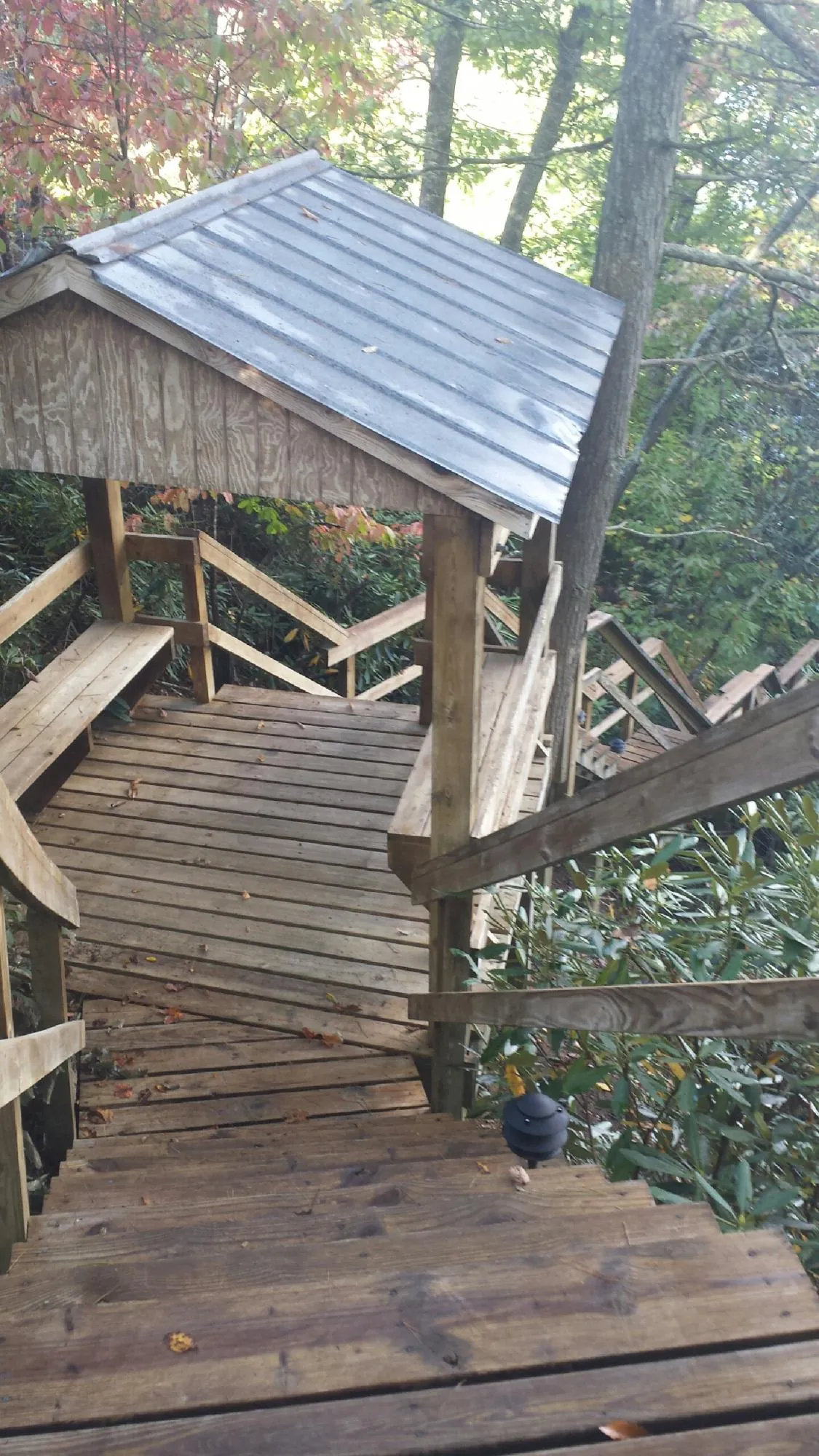 Metal roofed shelter over wooden steps on a wooded walkway — Skylight Repair & Installation work by our crew in Seaside Park